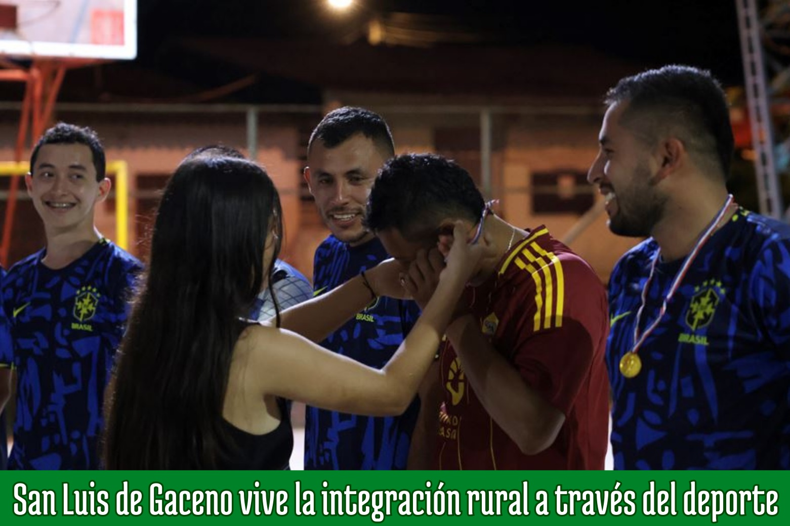 Premiación nocturna del torneo de fútbol de salón en Horizontes: una mujer le pone una medalla a un jugador junto a otros deportistas