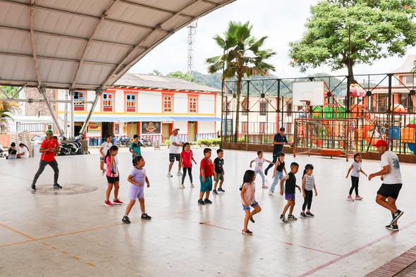 Niños y adultos bailan zumba en una cancha techada durante las Vacaciones Recreativas de San Luis de Gaceno