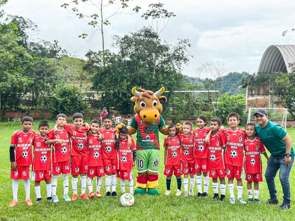 Niños de la Escuela de Fútbol San Luis de Gaceno posan junto a una mascota con forma de toro