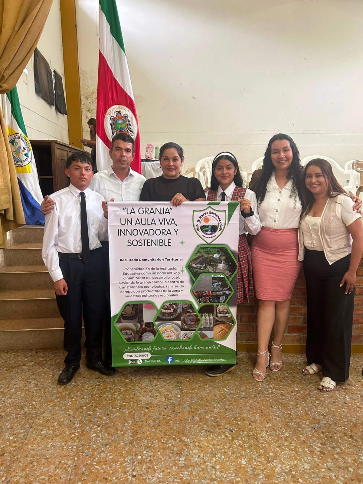 Estudiantes y adultos de la IE Nueva Esperanza de Santa Teresa con el pendón de la granja escolar «La granja, un aula viva»