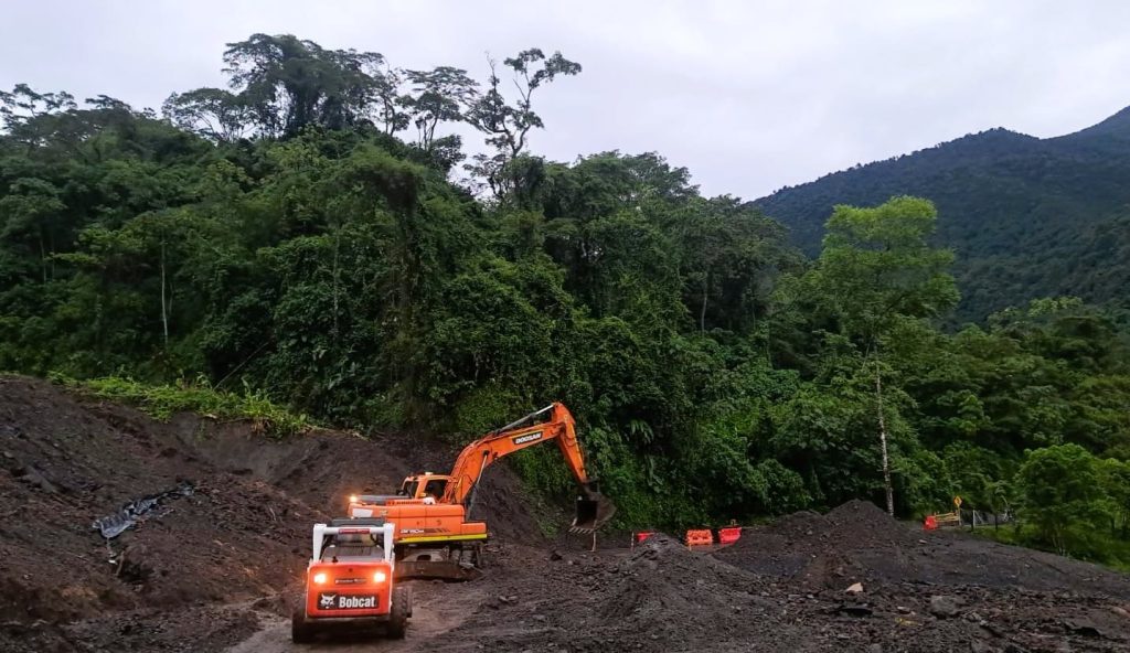 Excavadora y minicargador retiran tierra de un derrumbe en una vía de montaña de la Transversal del Sisga
