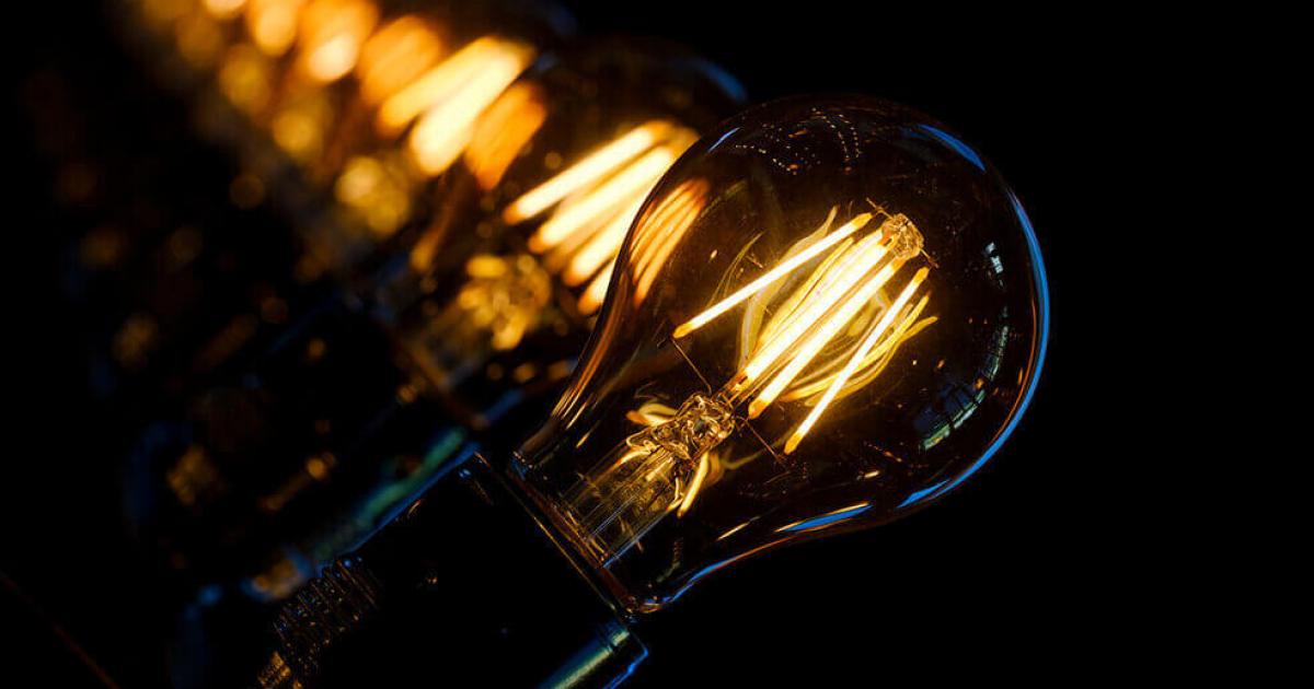 Bombillas encendidas sobre fondo oscuro, uso responsable ante el riesgo de racionamiento de energía