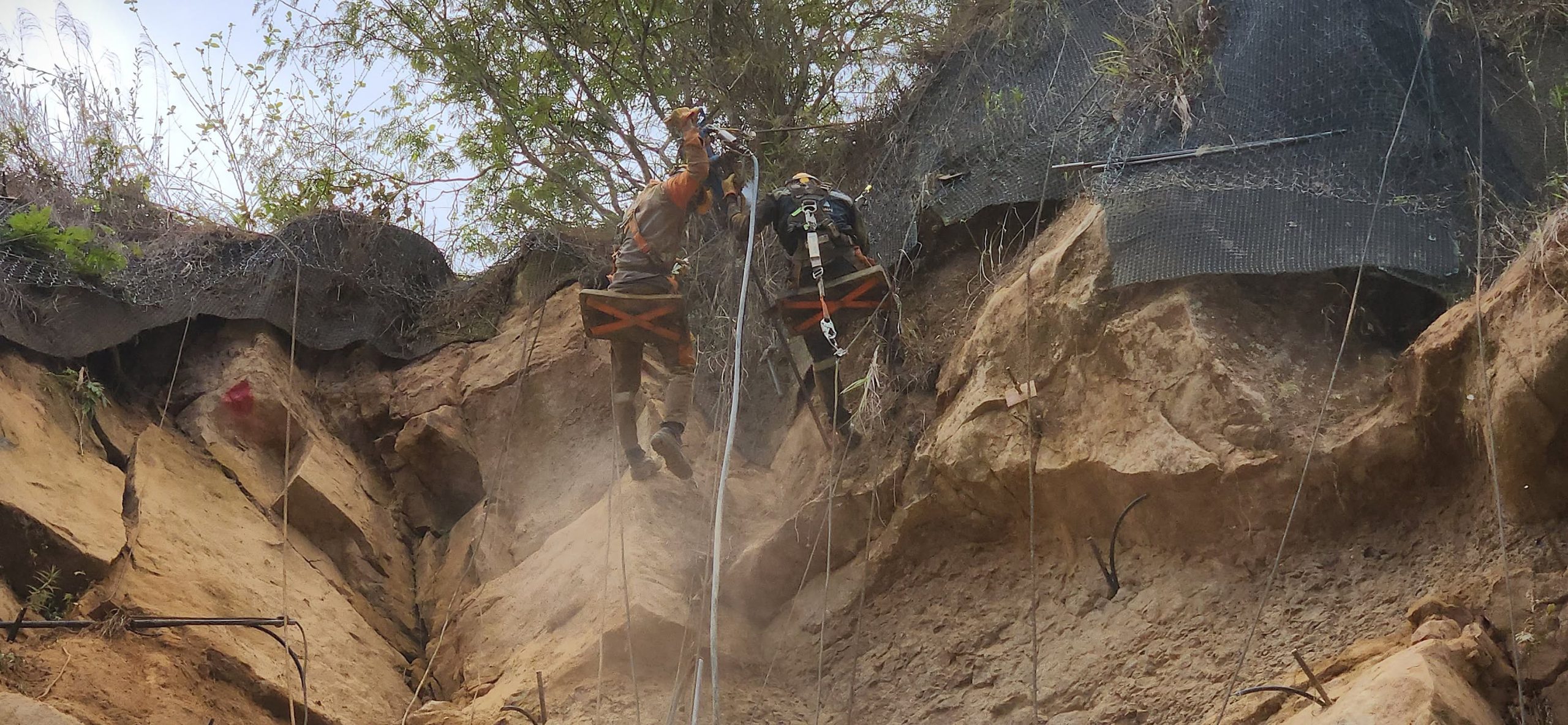 Operarios con arneses trabajan en el talud superior de la Transversal del Sisga, sector San Luis de Gaceno–Sabanalarga