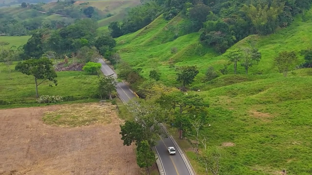 Vista aérea de un tramo de la Transversal del Sisga entre colinas verdes