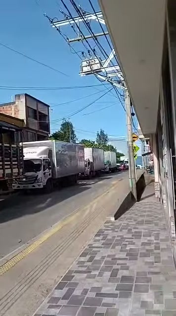 Camiones de carga detenidos en fila en una calle, en el trancón por la Transversal del Sisga en Guateque