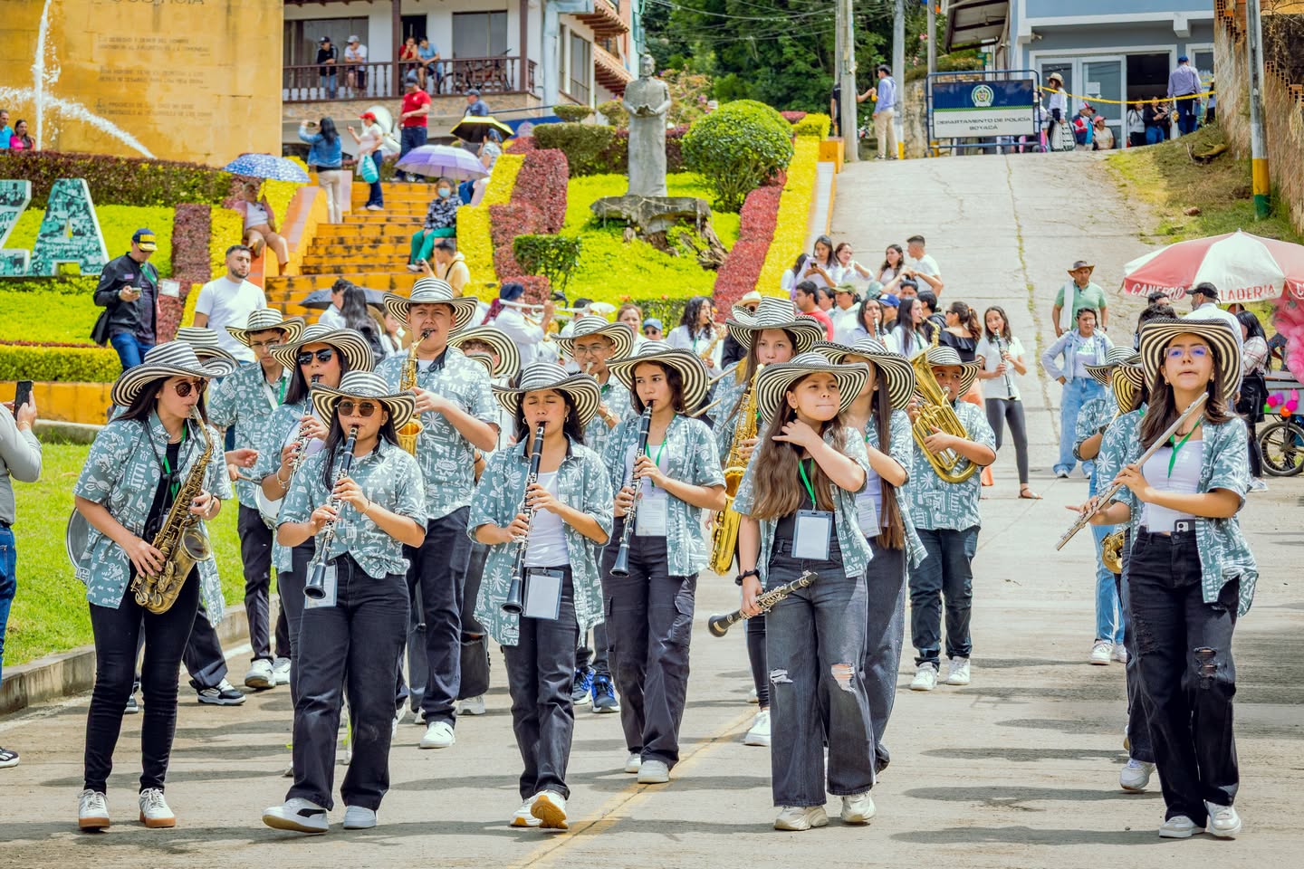 La banda de San Luis de Gaceno desfila mientras toca sus instrumentos de viento por una calle empinada