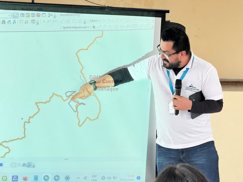 Expositor con camiseta de Corpochivor señala un mapa en la reunión de turismo en Chivor
