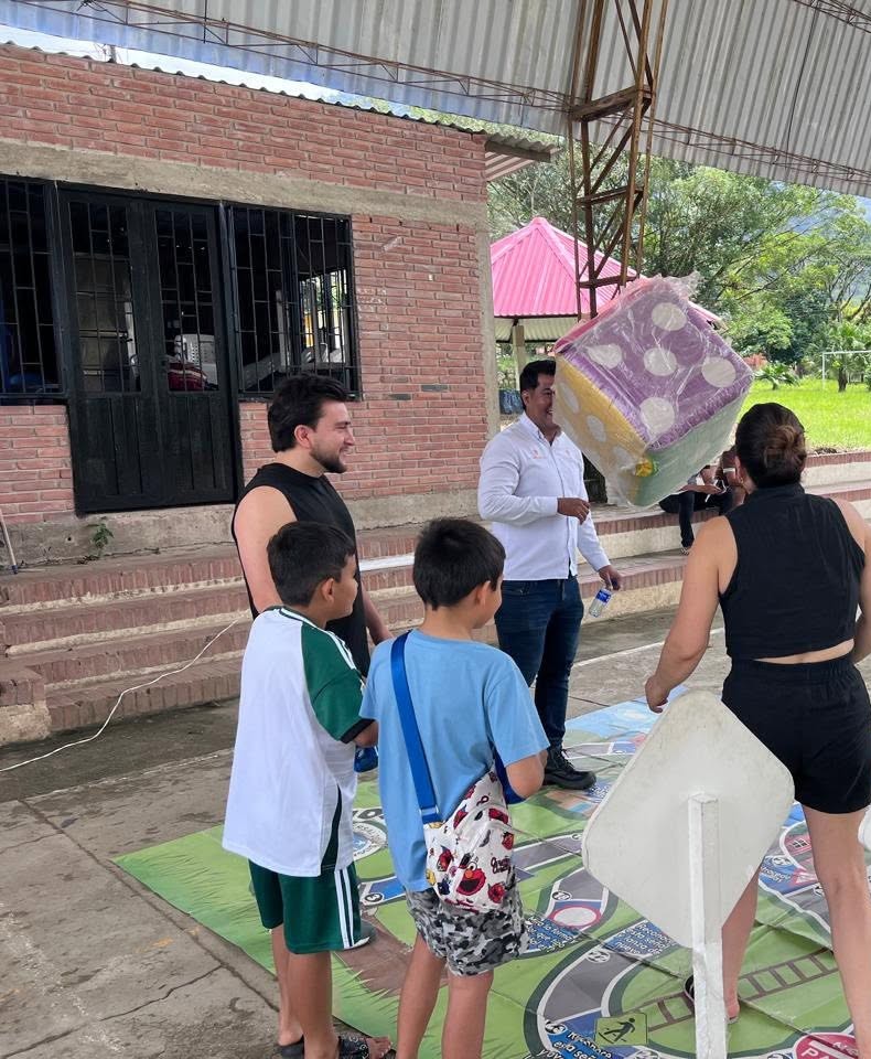 Campaña de cultura vial de la Concesión Transversal del Sisga en Santa Teresa, San Luis de Gaceno, con un dado gigante y un tablero en el piso