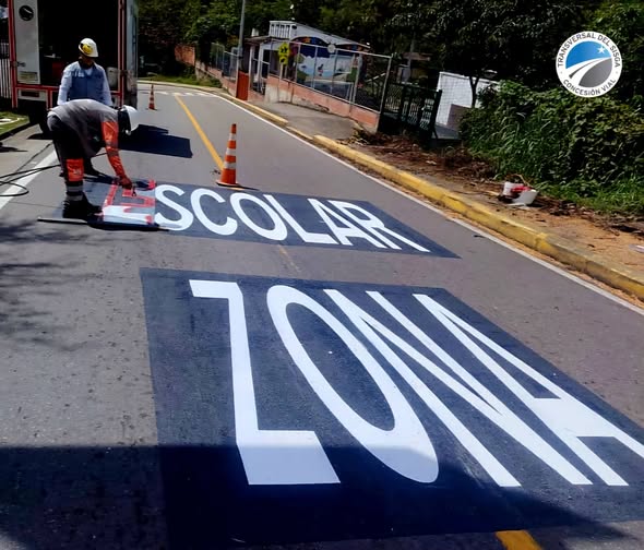 Operarios pintan la señal de zona escolar en la Transversal del Sisga