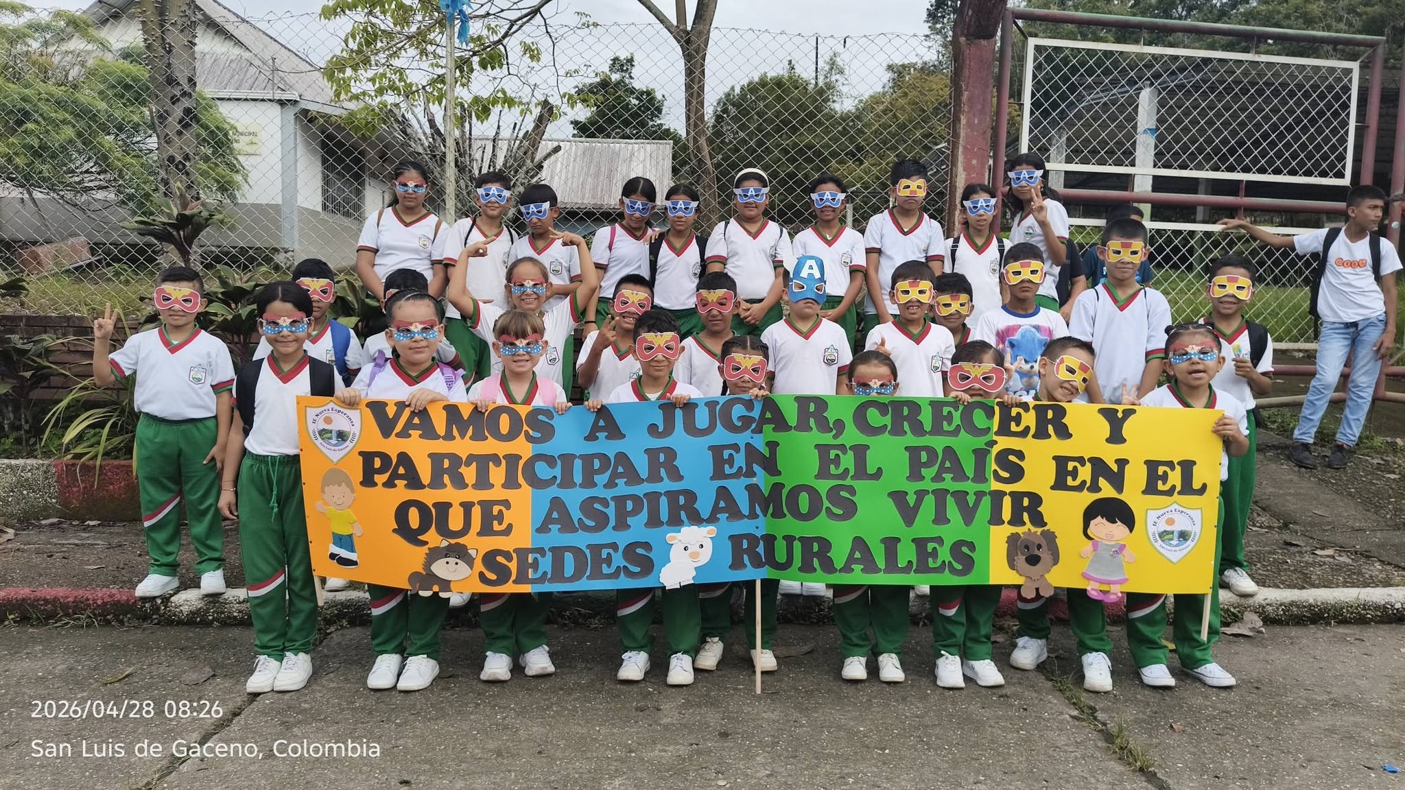 Estudiantes de la IE Nueva Esperanza con antifaces de papel y una pancarta en el Día del Niño en San Luis de Gaceno