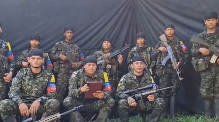 Hombres armados y uniformados frente a una tela negra en el video del Frente 28 de las disidencias de las FARC