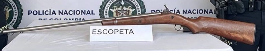 Escopeta de cañón largo y culata de madera sobre una mesa con mantel blanco