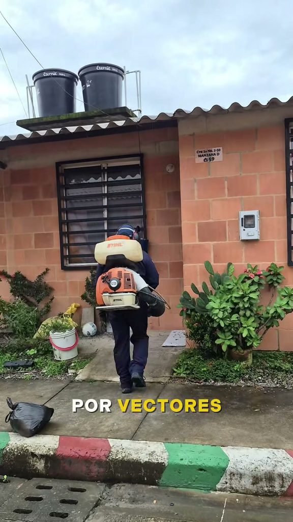 Operario con fumigadora de motor entra a una vivienda por el dengue en el barrio El Progreso de San Luis de Gaceno