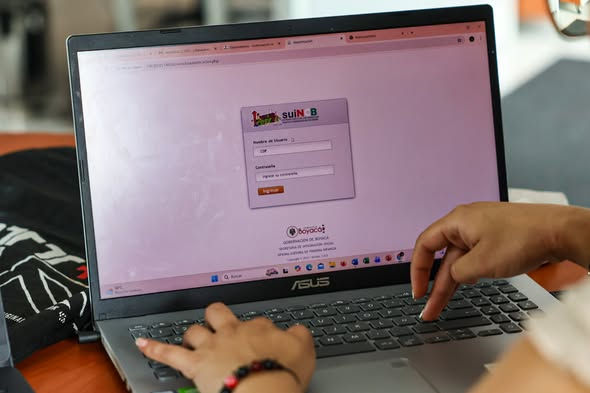 Manos sobre el teclado de un portátil con la página de ingreso del sistema de la Gobernación de Boyacá