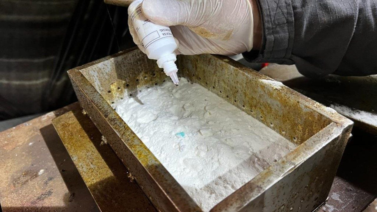 Prueba con reactivo sobre una bandeja metálica con polvo blanco, en un operativo contra laboratorios de cocaína en el Valle de Tenza