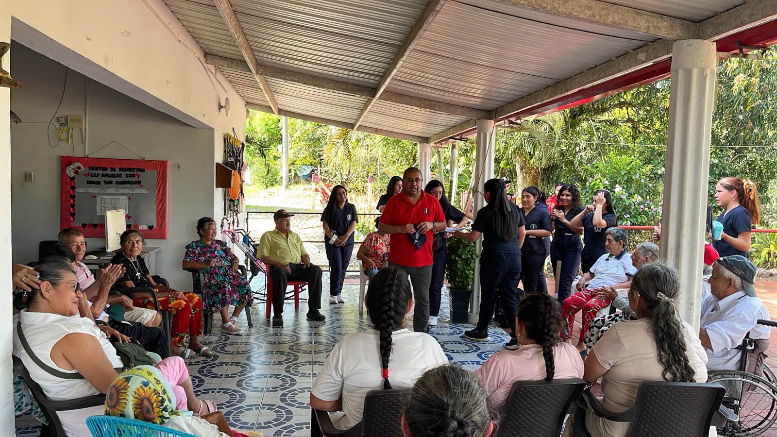 Adultos mayores y estudiantes reunidos bajo el techo del Centro de Bienestar