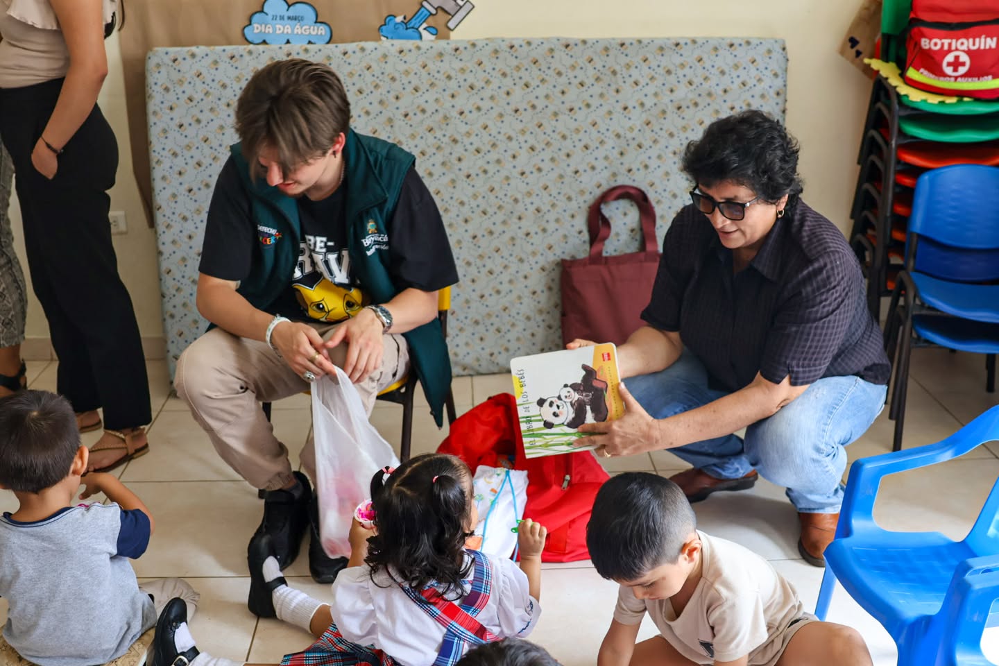 Funcionario de la Gobernación de Boyacá con niños sentados en el suelo durante la Maleta Viajera en San Luis de Gaceno