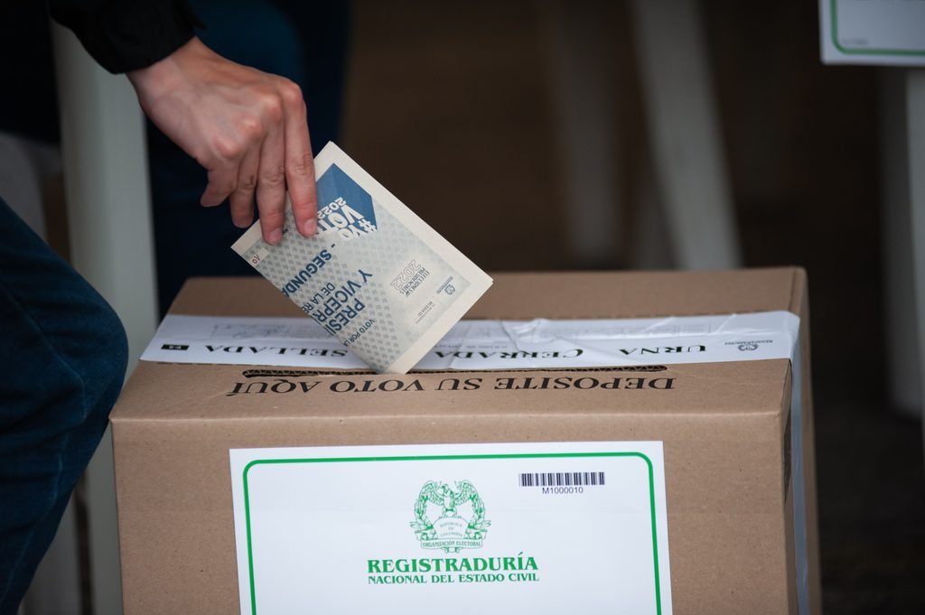 Una persona deposita su voto en una urna de la Registraduría Nacional del Estado Civil