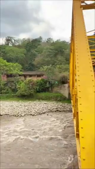 Puente Quigua, en Tenza, con sus barandas amarillas sobre el río