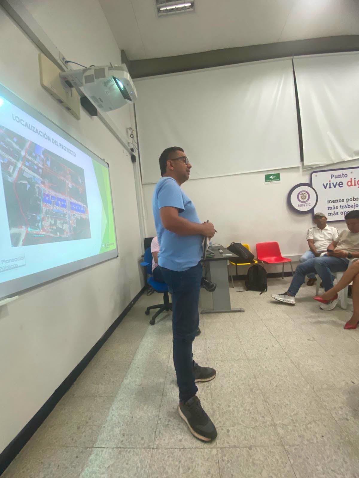 Un hombre de camisa azul presenta en una pantalla el mapa con la localización del proyecto de gas en Sabanalarga