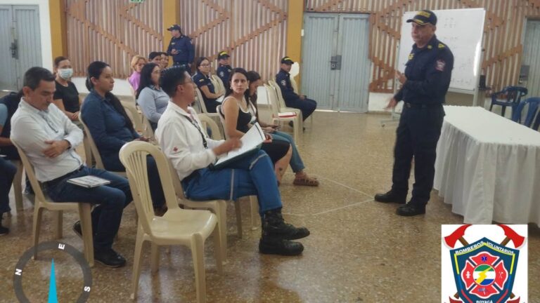 Un bombero de Santa María, de uniforme azul oscuro, habla de pie ante un grupo de funcionarios sentados en sillas plásticas