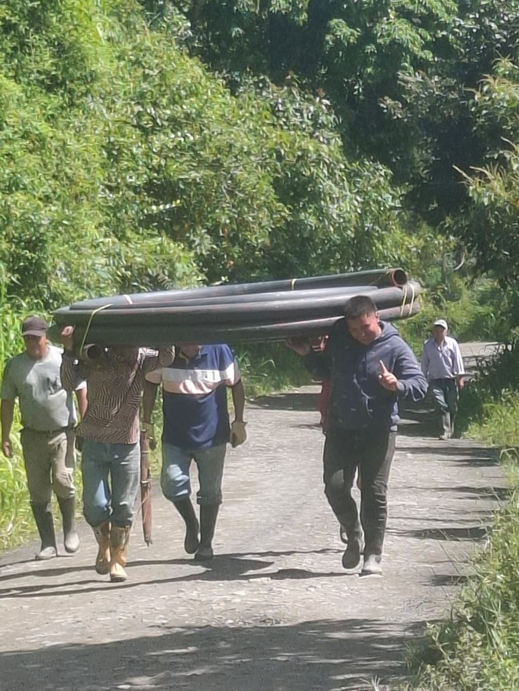 Vecinos cargan tubos de drenaje durante la recuperación de la vía Los Militares